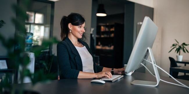 A manager learning Salesforce Sales Cloud on her computer